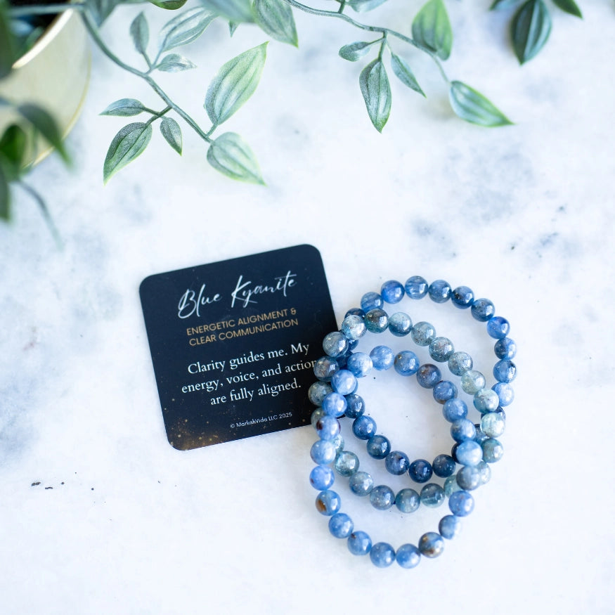 The Evoline Blue Kyanite Energetic alignment and clear communication bracelet shown with meaning card and stacked bracelet style. 