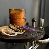 Decorative Align candle from The Evoline with beads on a dark surface