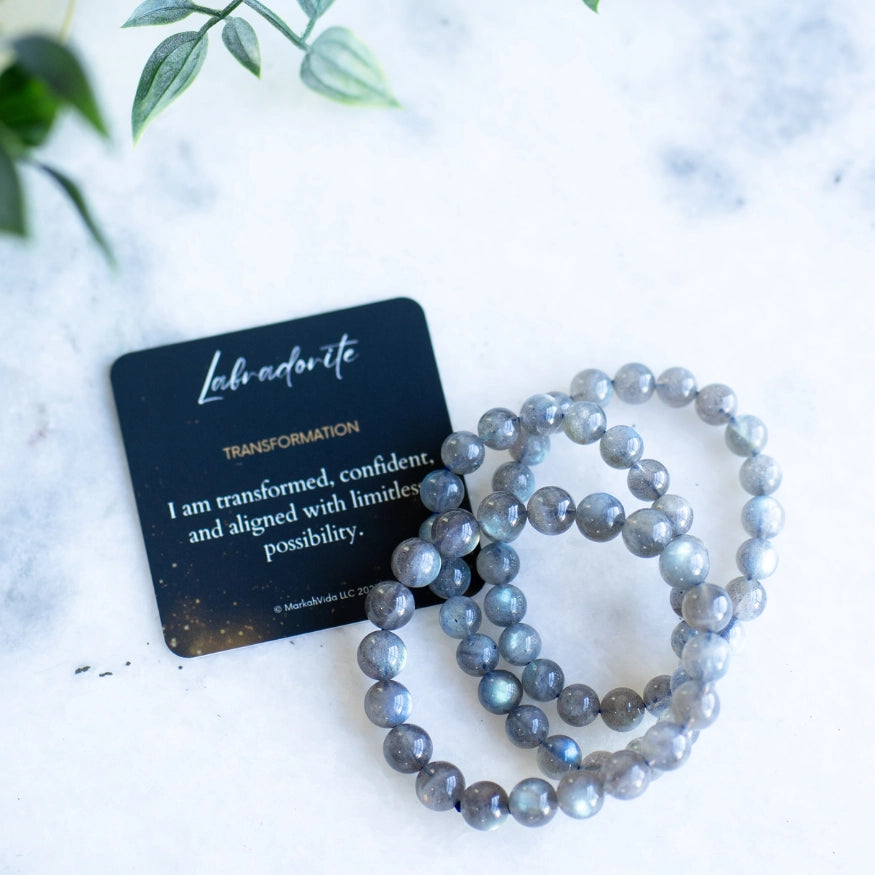 The Evoline Labradorite Transformation Bracelet shown with meaning card and stacked style bracelets.