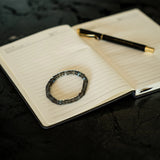 Labradorite cylinder transformation Bracelet on a notebook with a pen