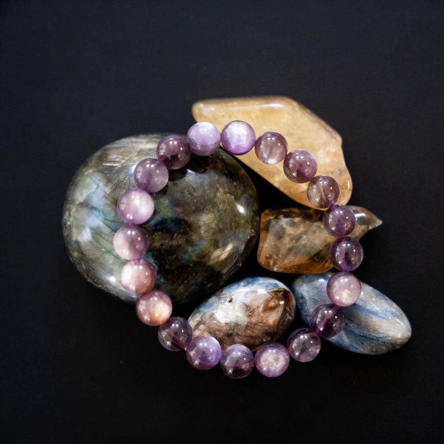 The Evoline Lepidolite Serenity & Emotional Balance Bracelet on natural elements.